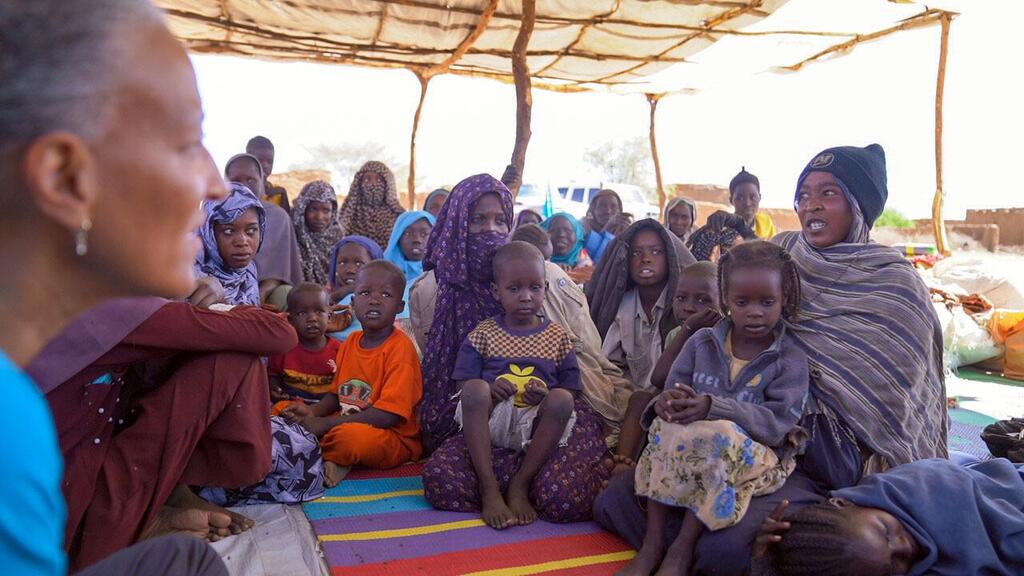 الشابة السودانية ضحى البالغة من العمر 17 عاما (على اليمين) تتحدث مع مسؤولة في اليونيسف في مركز في منطقة طويلة، يستقبل الفارين من العنف في الفاشر.